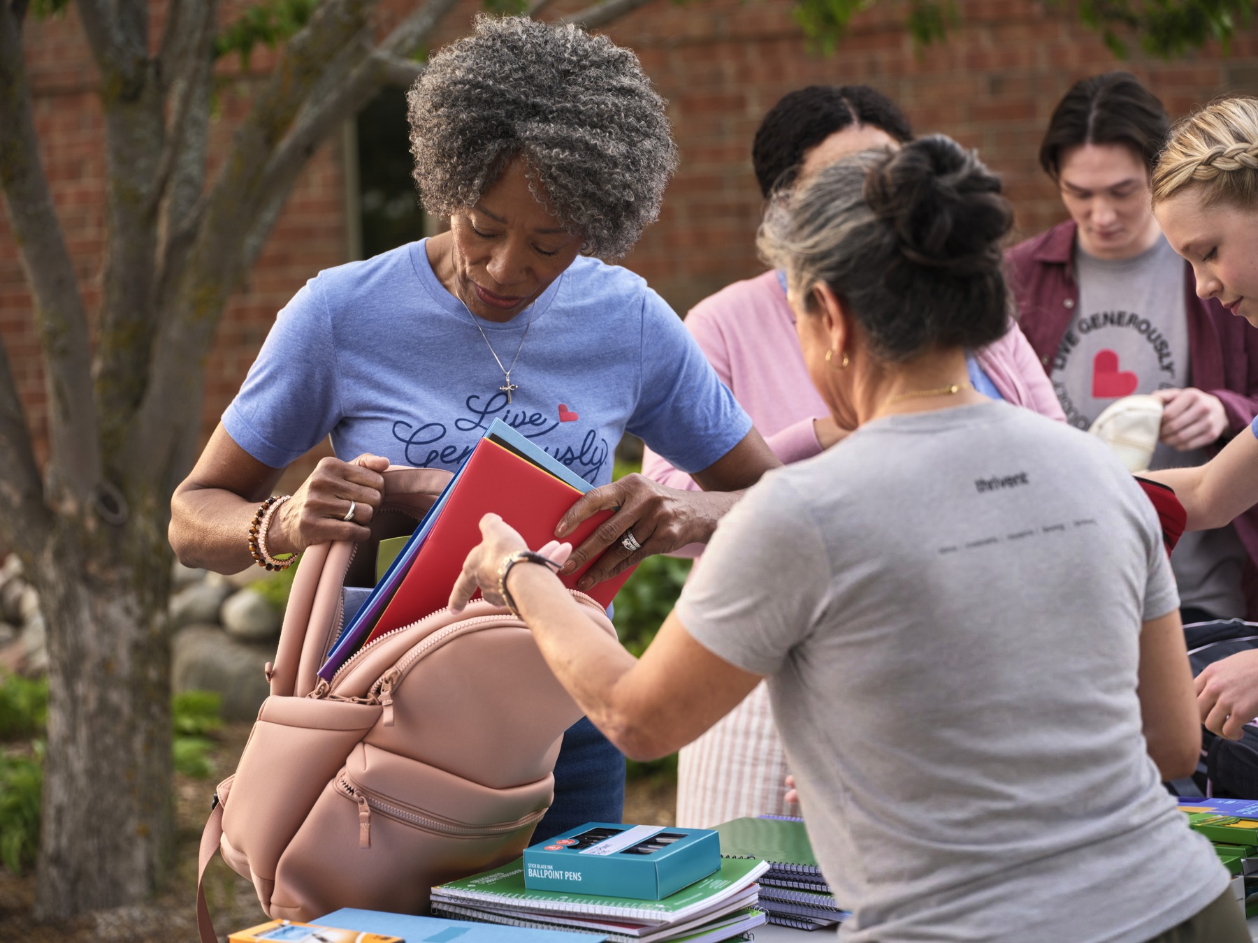 Volunteers packing backpacks with school supplies in a Thrivent program photograph