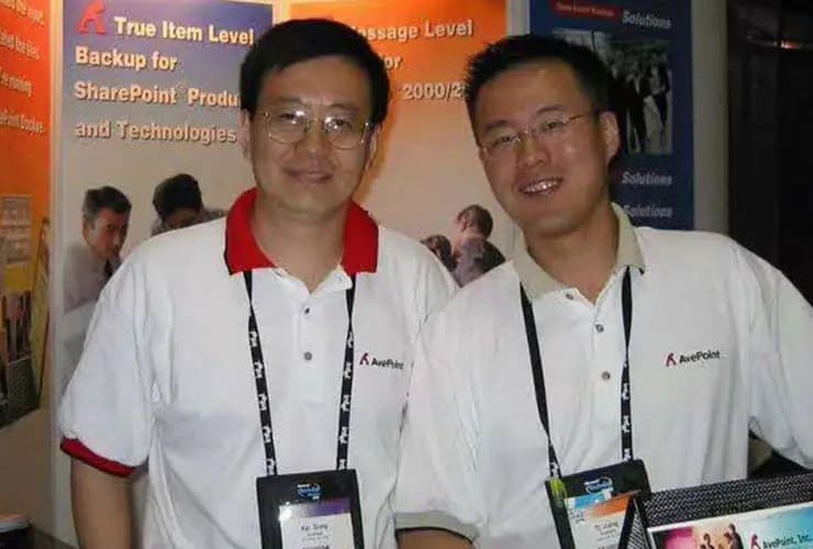 Tianyi Jiang and Kai Gong wearing AvePoint shirts at a Microsoft technology event in 2003
