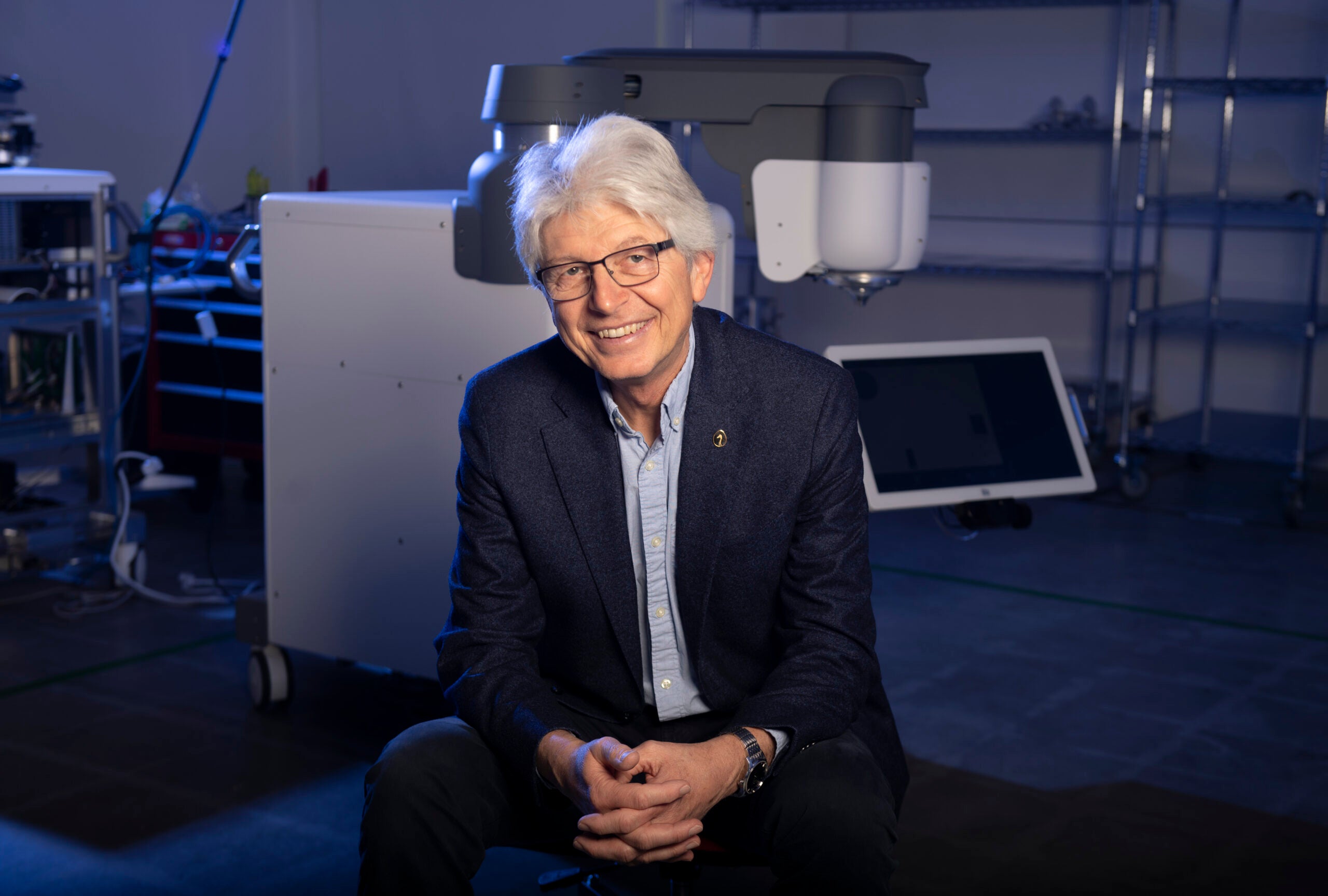 Tibor Juhasz seated beside laser equipment at ViaLase in Aliso Viejo