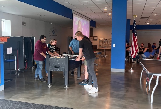 TicketNetwork staff playing foosball in the company cafeteria