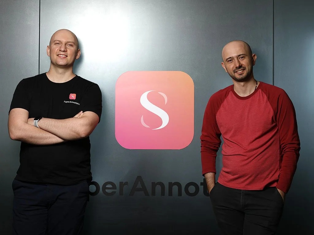 Tigran Petrosyan, left, and his brother Vahan beside the SuperAnnotate logo