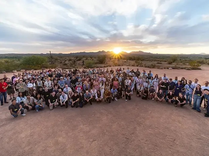 Tilt employees gathered outdoors at sunset during a company gathering