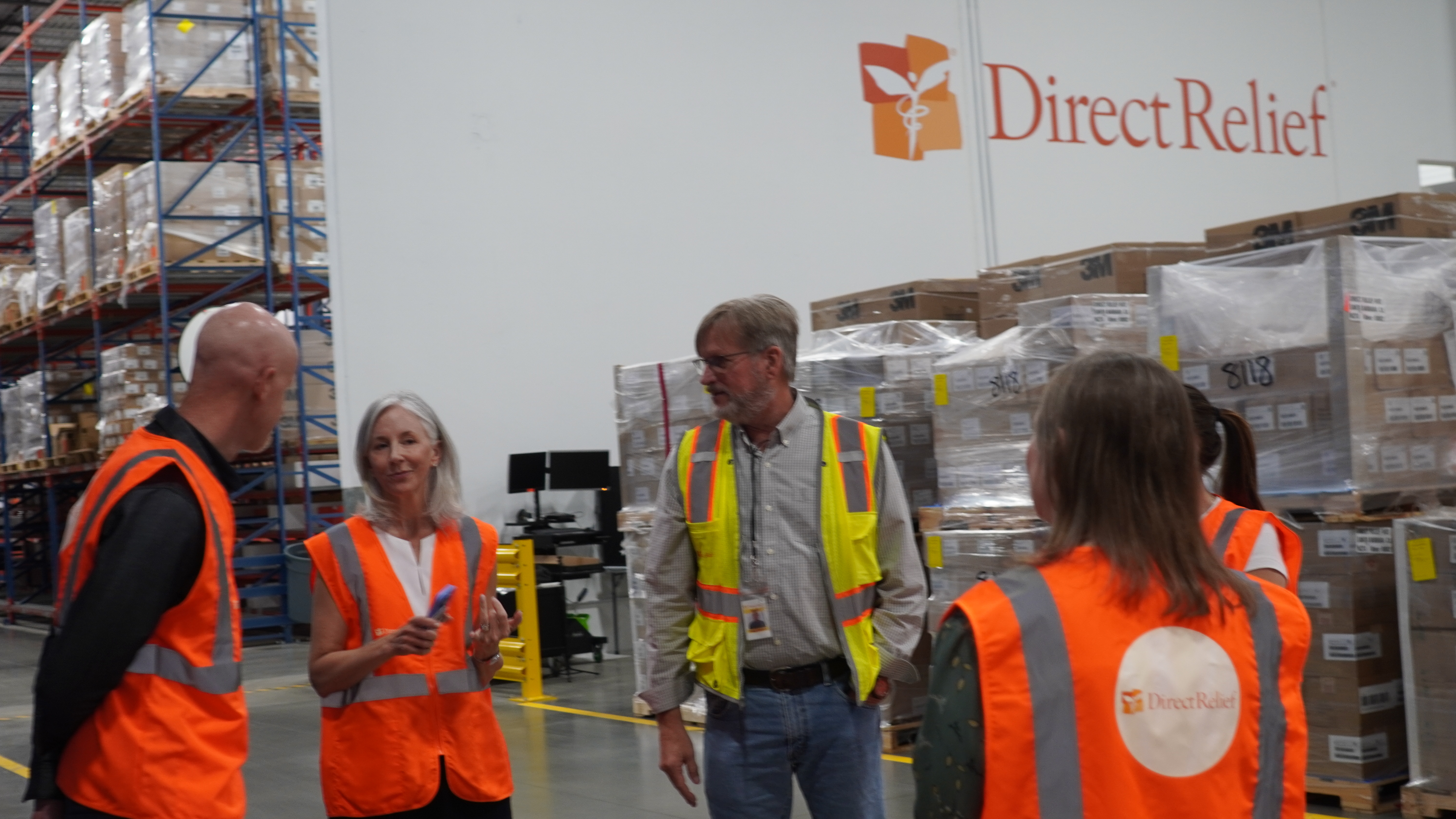 Tim Cadogan, at left, joins a warehouse tour at Direct Relief in Santa Barbara