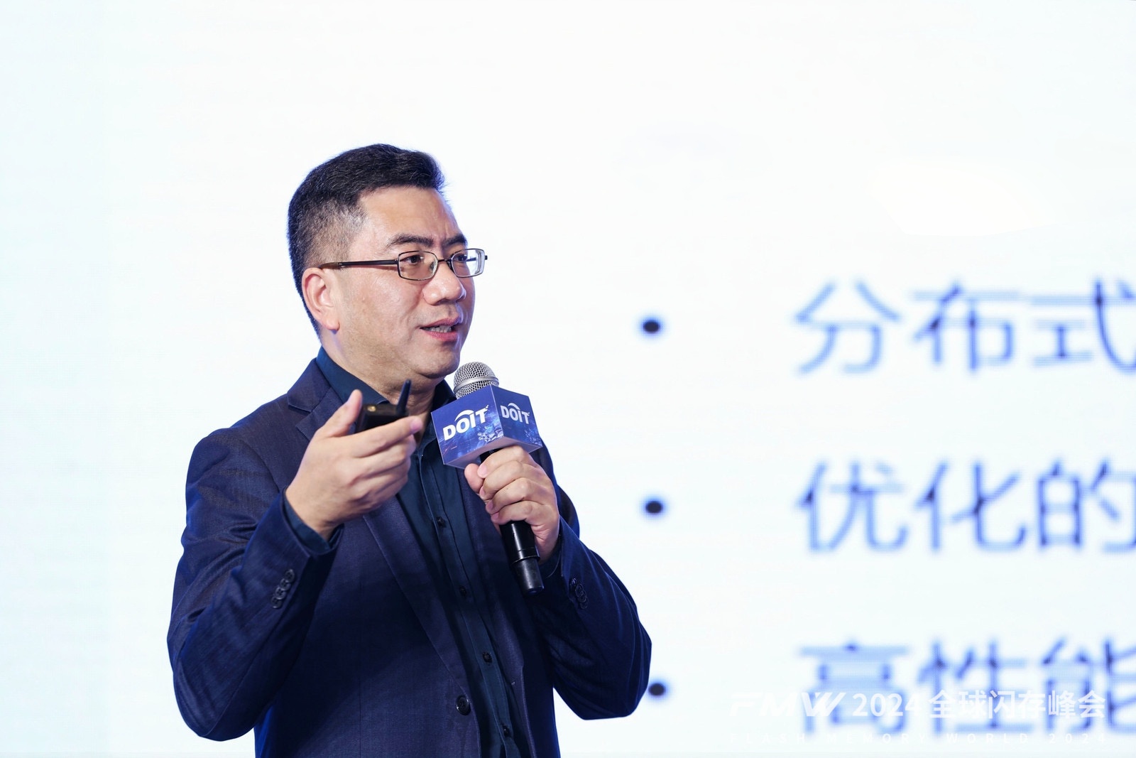 Tim Ding speaking into a microphone at Flash Memory World 2024
