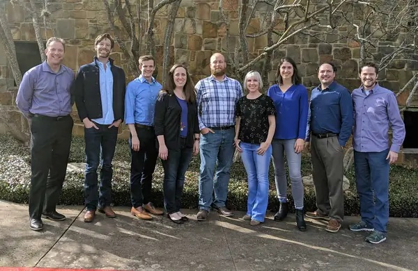 Praxent’s nine-person executive team outdoors in 2019, with Tim Hamilton at far right