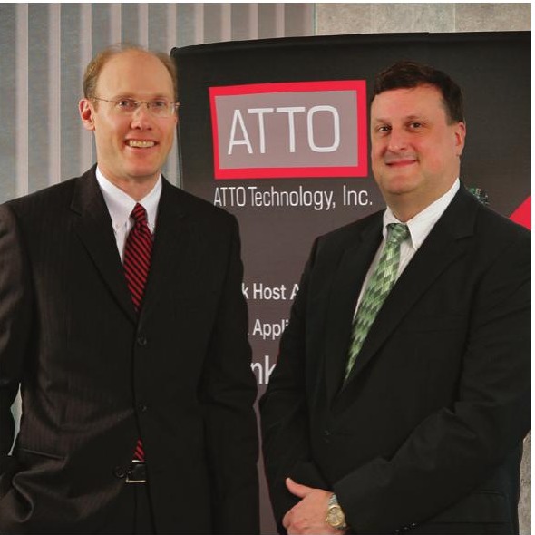 ATTO co-founders David Snell and Tim Klein standing in front of an ATTO Technology display