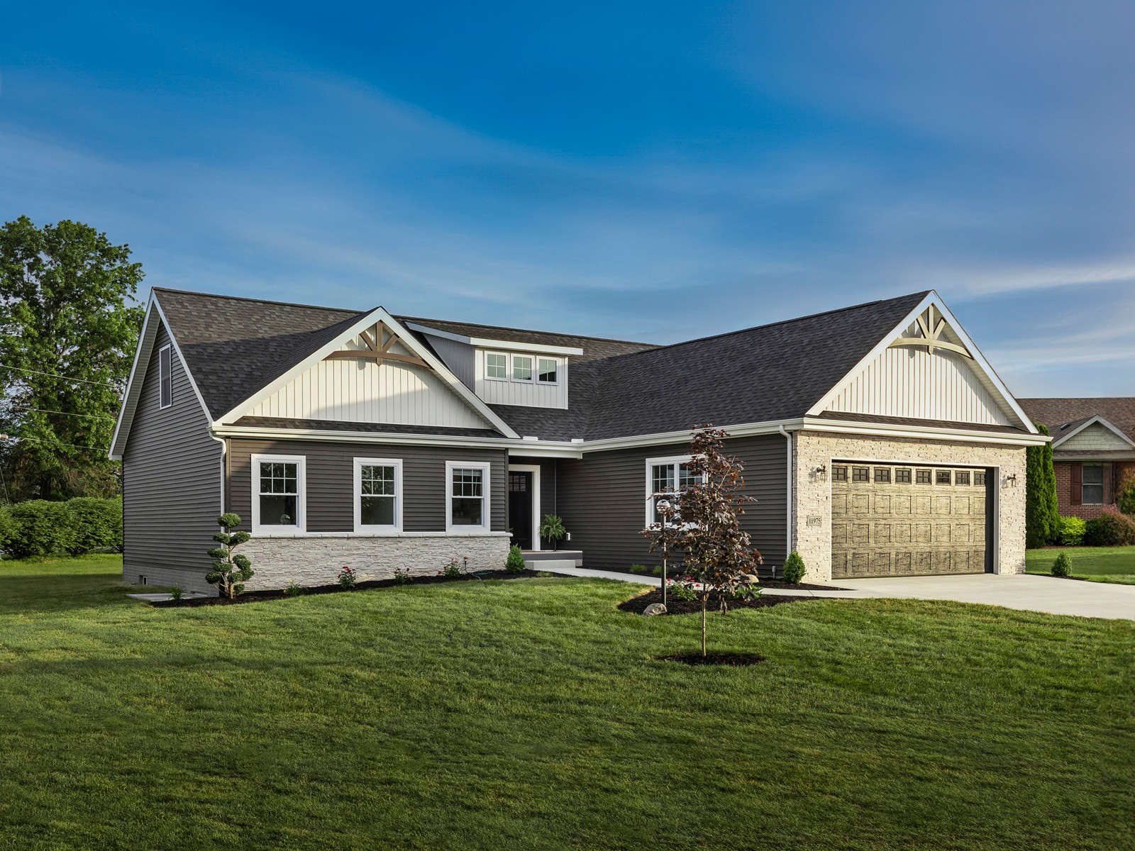 A modular home shown on Champion Homes’ website, with a pitched roof, front porch and attached garage
