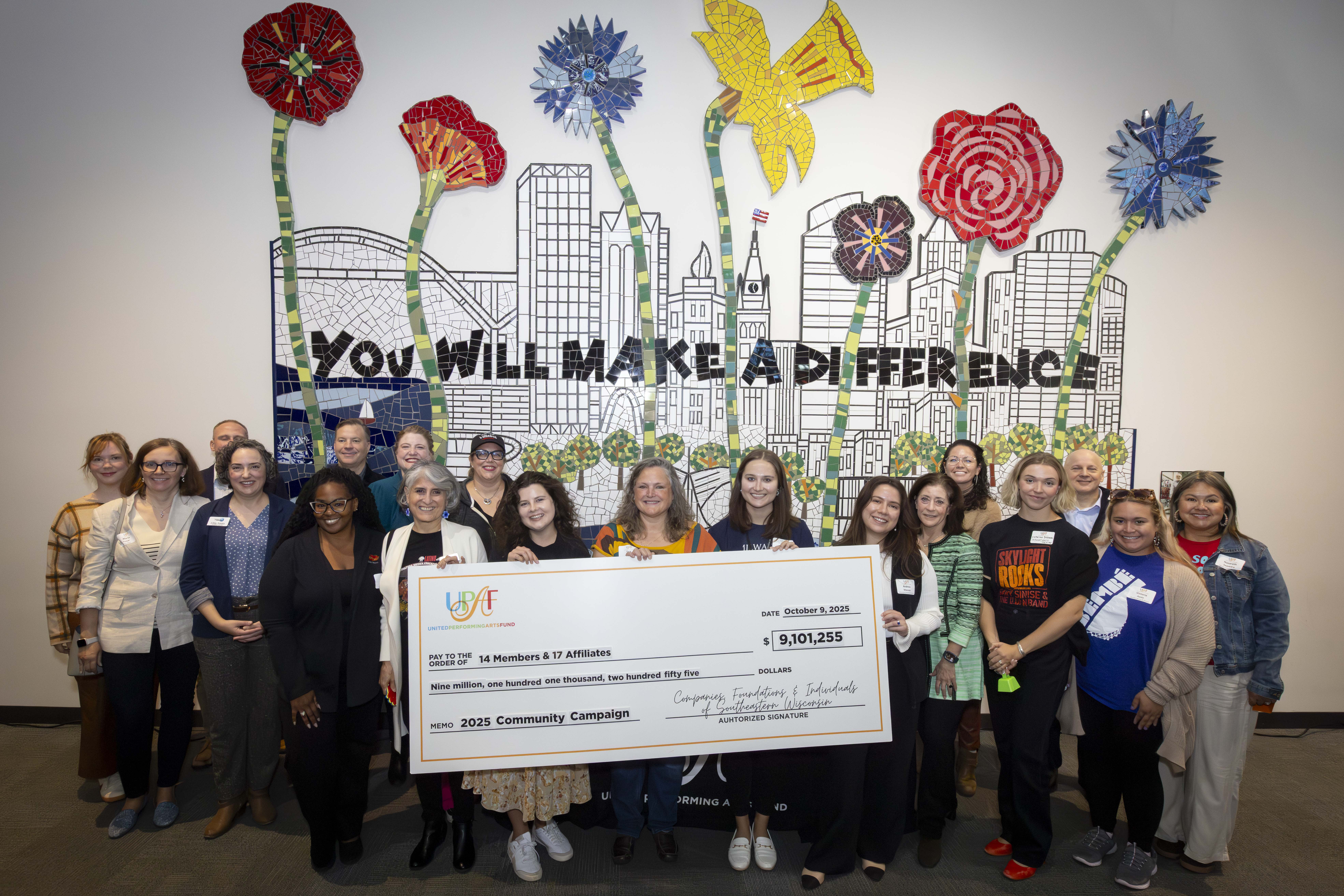 UPAF arts representatives gathered around the 2025 campaign check at Milwaukee Youth Arts Center