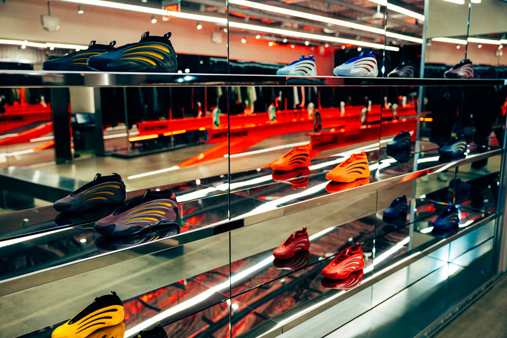 Colorful adidas Harden basketball shoes arranged on mirrored shelves at the launch