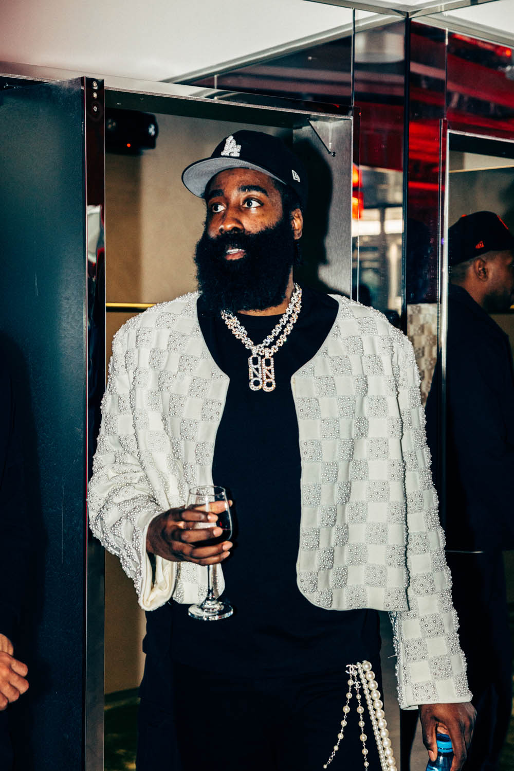James Harden holding a drink in the mirrored adidas event space