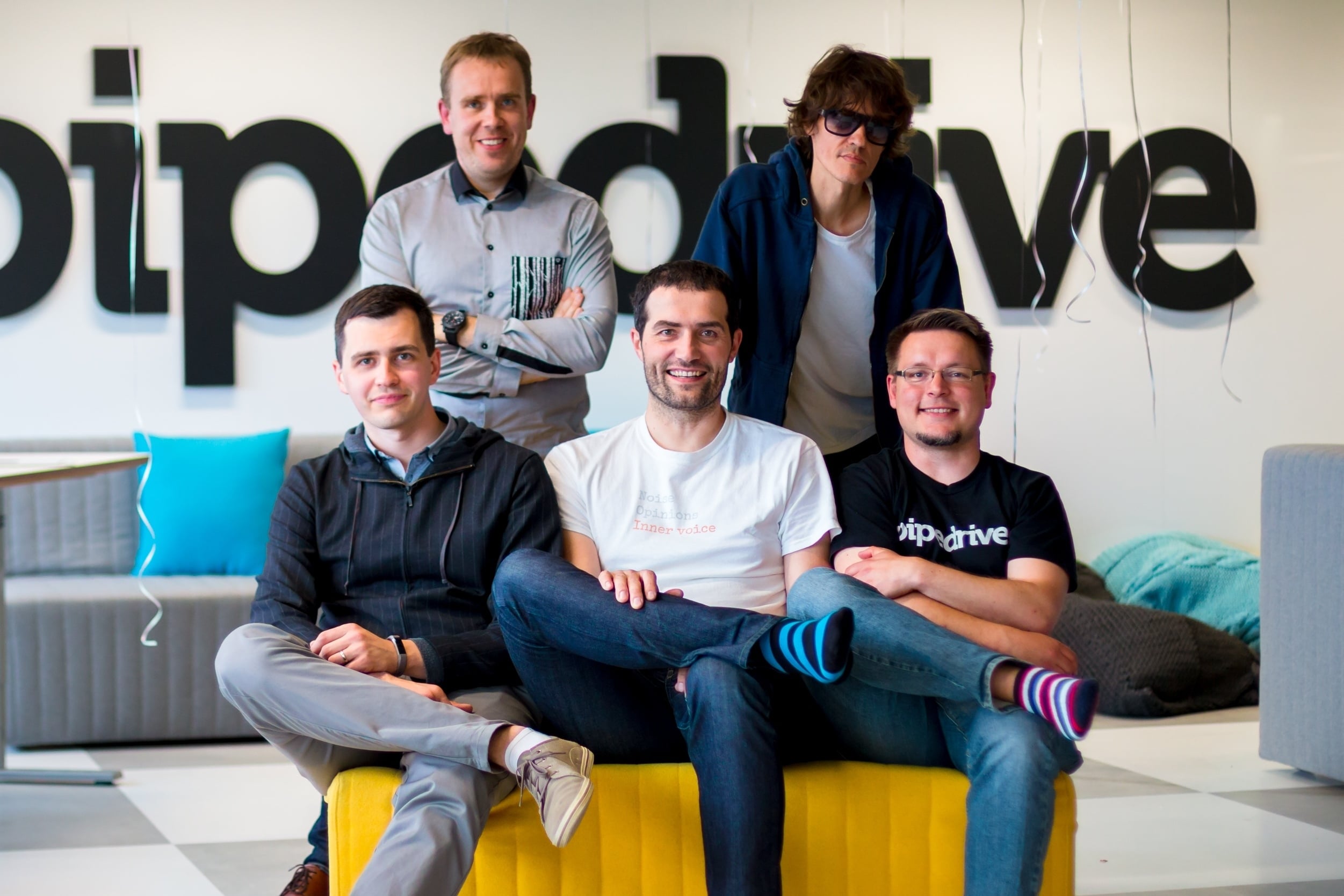 Pipedrive’s five co-founders gathered around a sofa, with Timo Rein seated in the center
