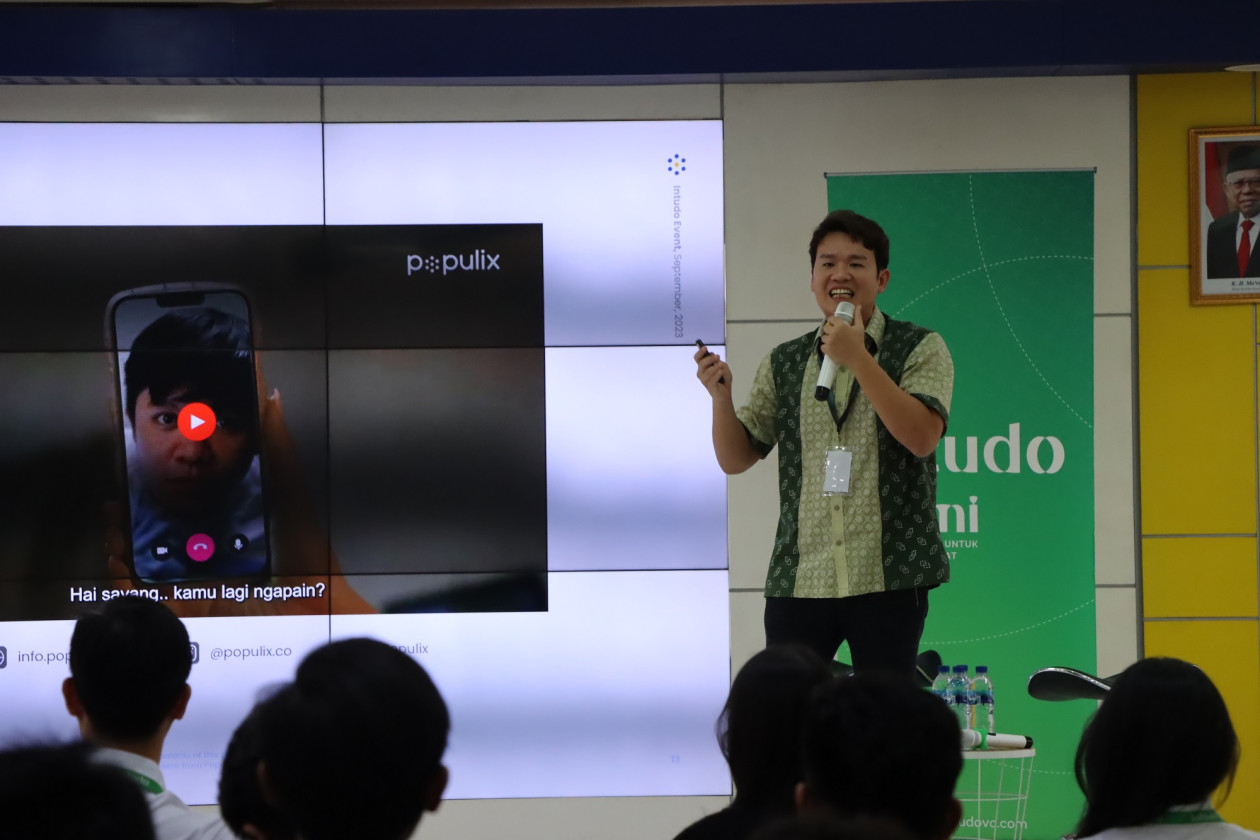 Timothy Astandu speaking into a microphone at a UGM startup discussion