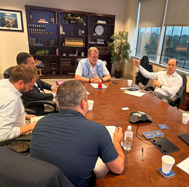 Tim Duncan gestures while meeting with analysts and colleagues around a conference table in Houston