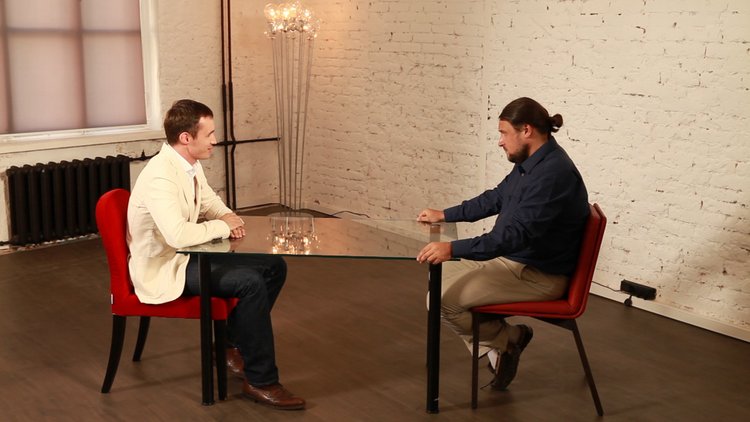 Timur Valishev, at left, speaking across a table with interviewer Oleg Anisimov