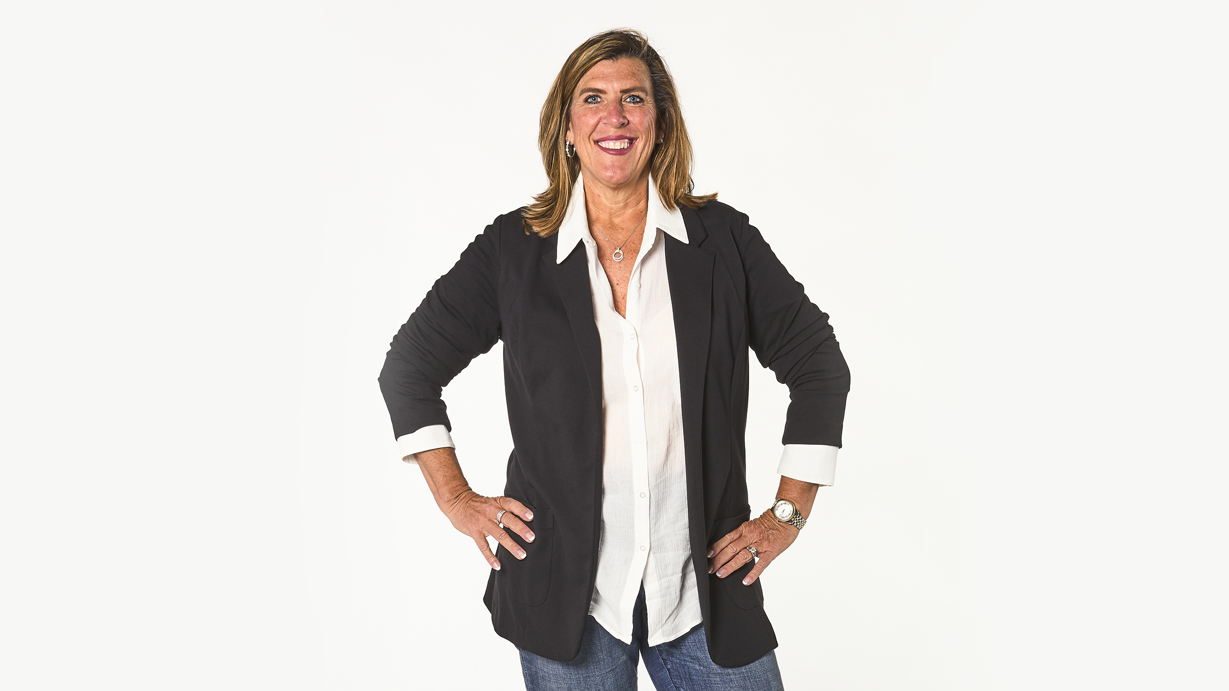 Tina VonderHaar standing in a black blazer against a white studio background