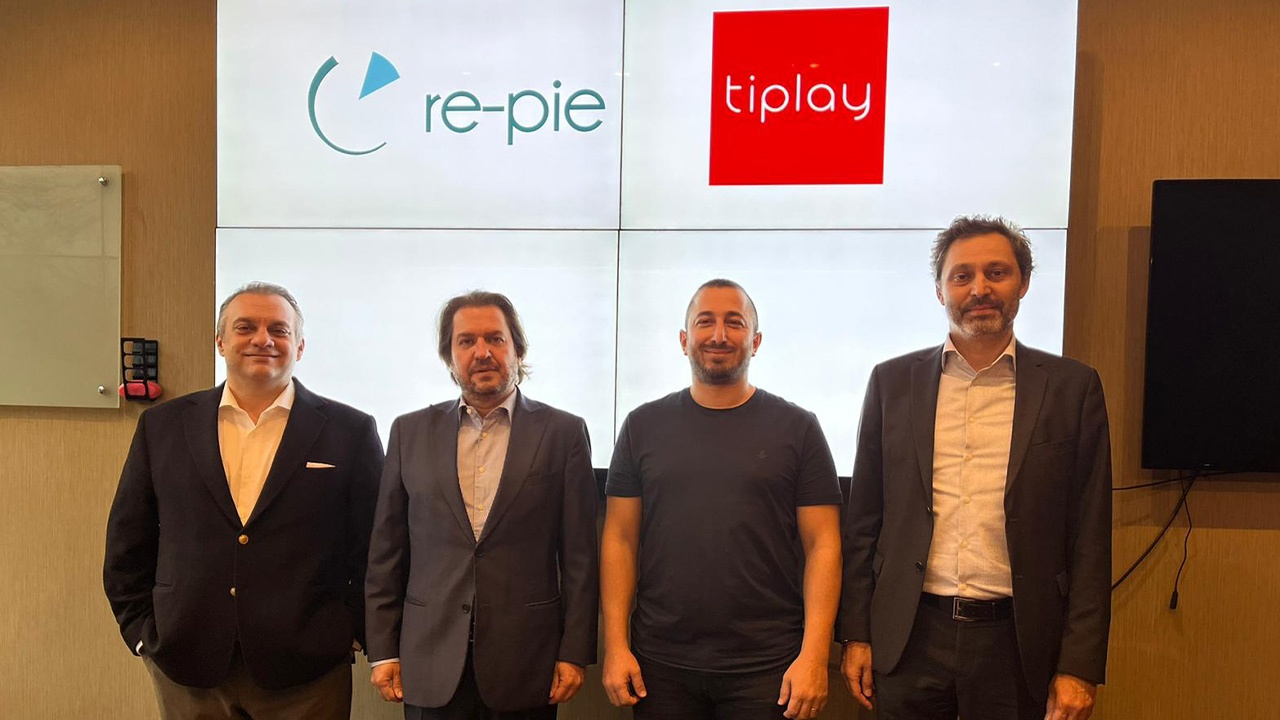 Four people at tiplay’s funding announcement, standing beneath Re-Pie and tiplay signage