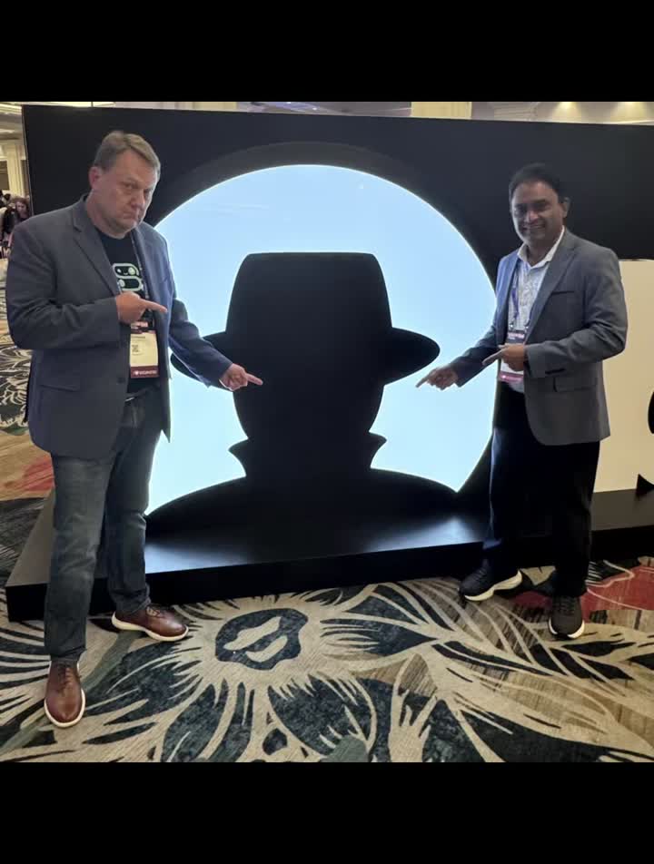 Rob Kocerha, left, and Tippu Gagguturu, right, beside a Black Hat event display
