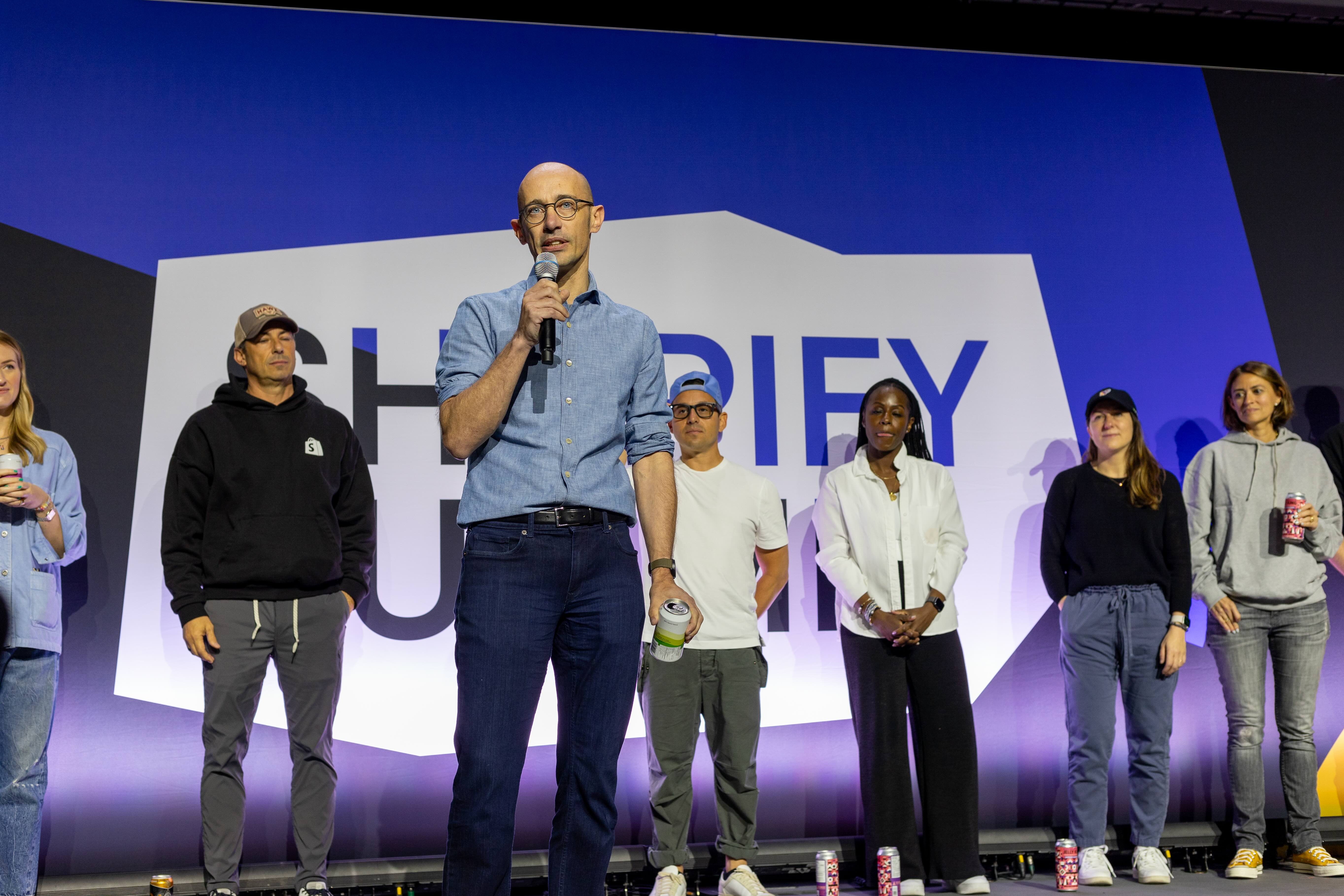 Tobias Lütke speaking on stage to Shopify employees in 2024