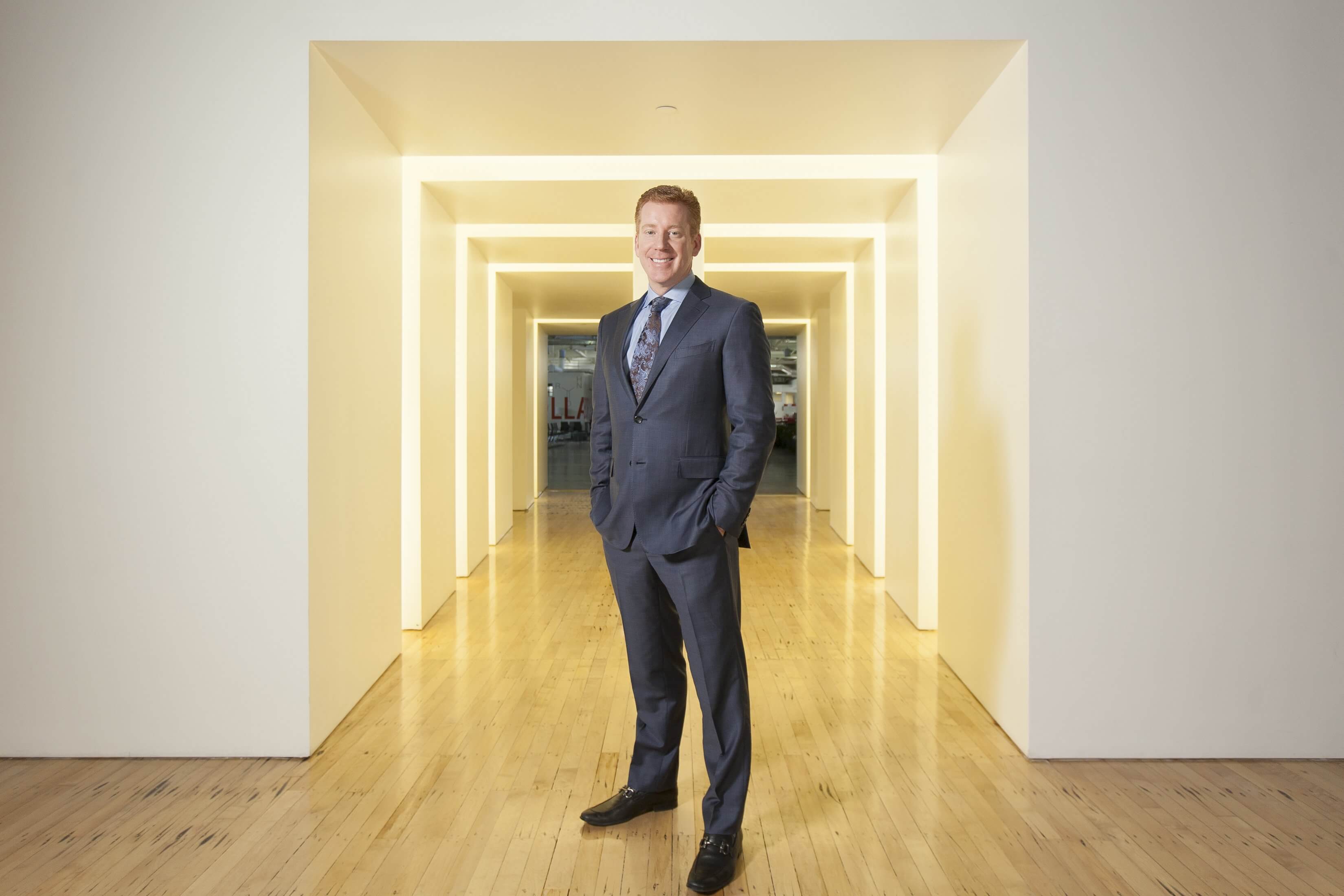 Toby Hamilton standing in a series of yellow-lit doorways at TMC Innovation