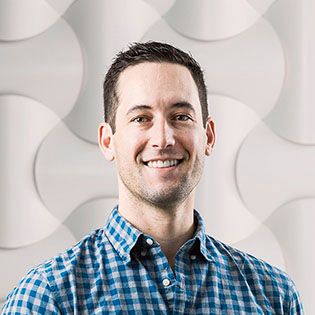 Toby Scammell smiling in a blue checked shirt