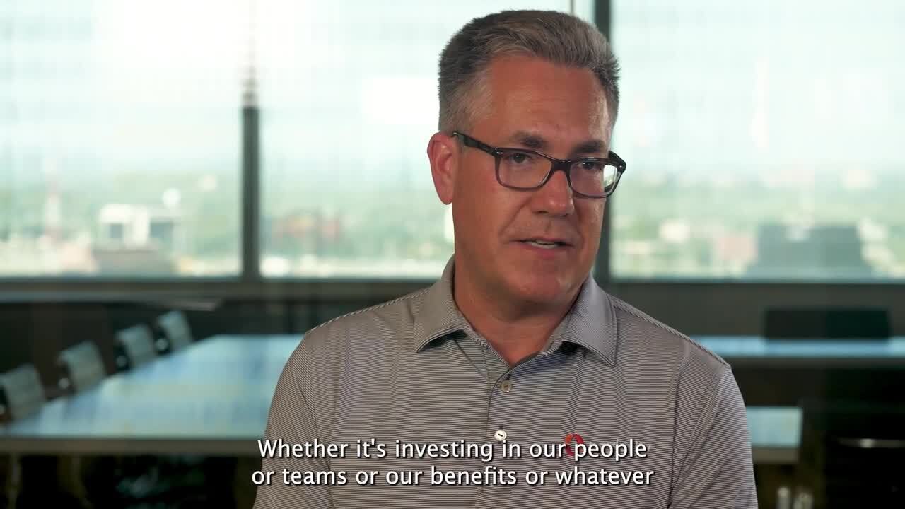 Toby Williams speaking in a Paylocity careers video, seated beside a conference table