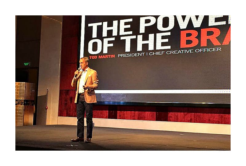 Tod Martin holding a microphone on stage at New Era’s 2015 Hong Kong conference
