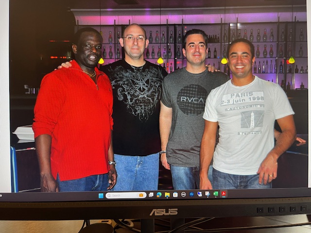 An archival group photograph with Todd Greenbaum standing at the far right