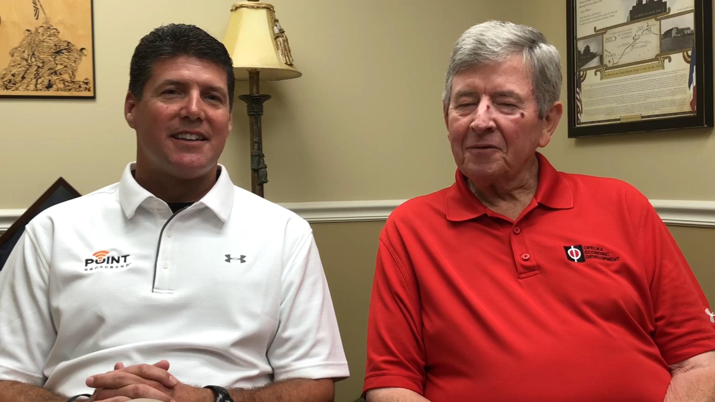 Todd Holt, left, seated beside Opelika mayor Gary Fuller in a Point Broadband video