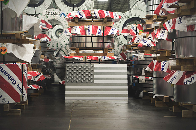 A sculpted American flag made from steel, displayed against a steel background