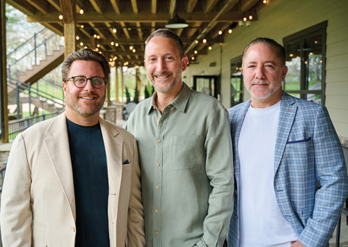 Todd Leebow, chef Brad Race and Jon Gross standing together on the covered patio at 1818 Grille
