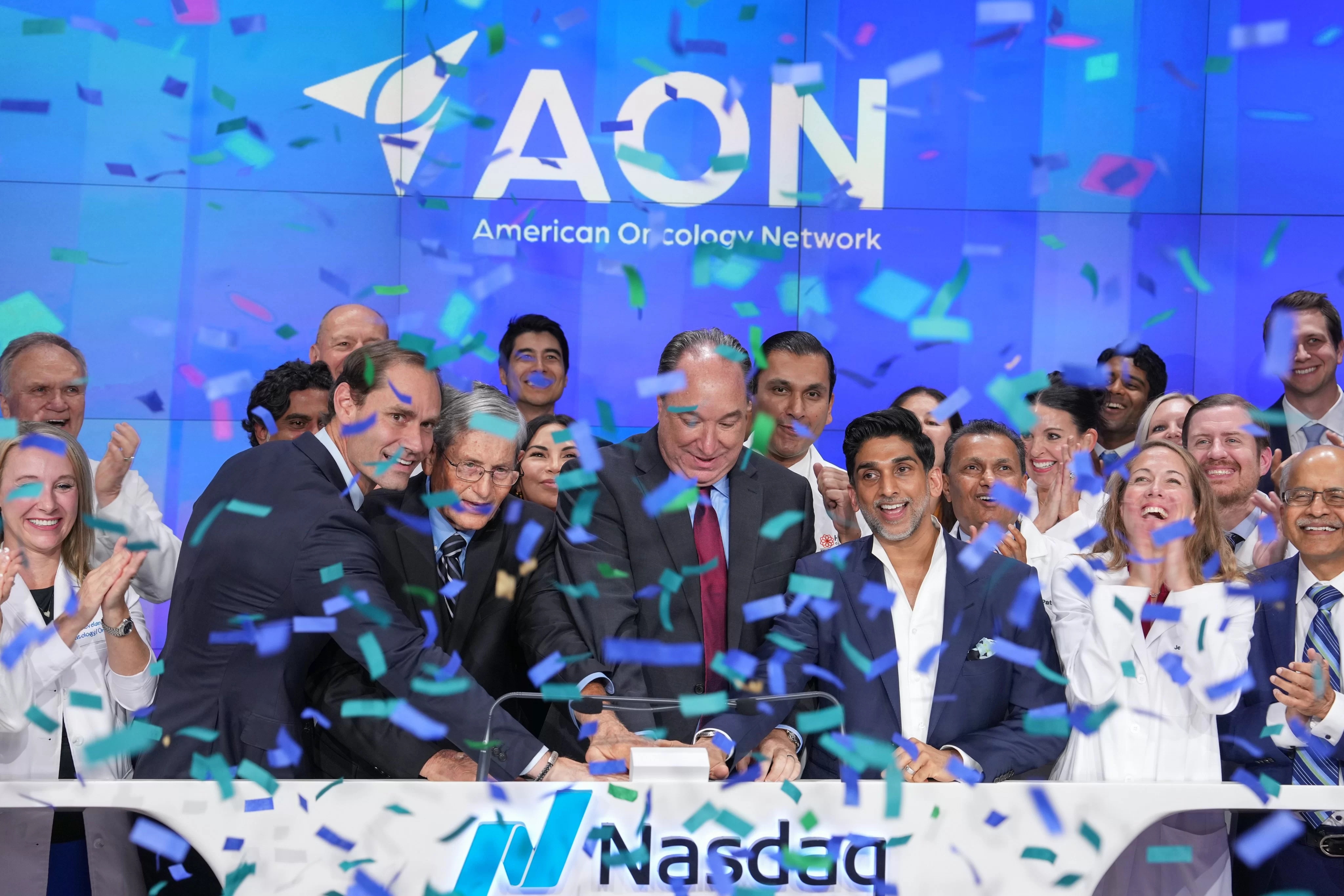 AON executives and colleagues celebrate beneath falling confetti at the Nasdaq closing bell ceremony