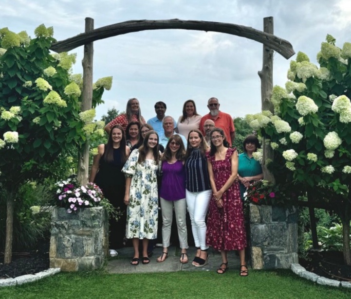 The Hooked & Company team gathered beneath a wooden garden arch in July 2024
