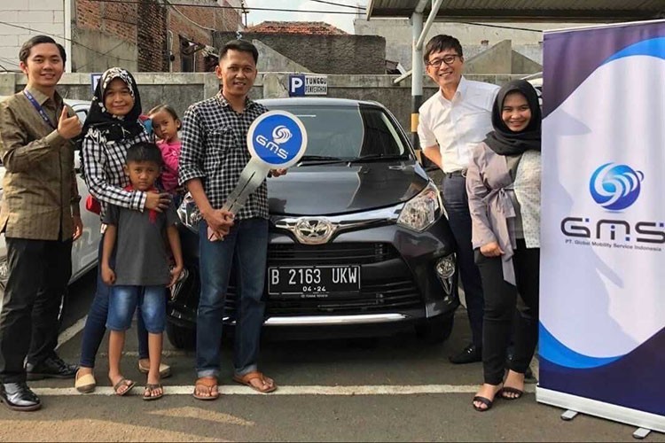 Tokushi Nakashima with Global Mobility Service customers beside a car in Indonesia