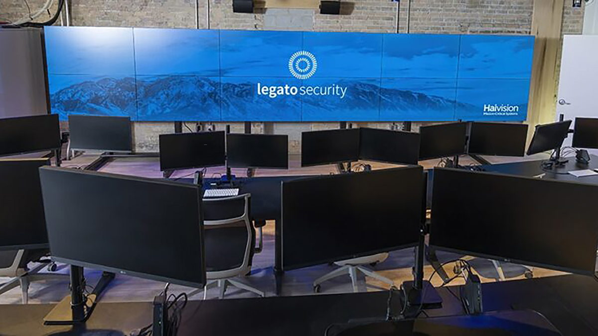 Legato Security operations center with rows of analyst monitors facing a twelve-screen video wall