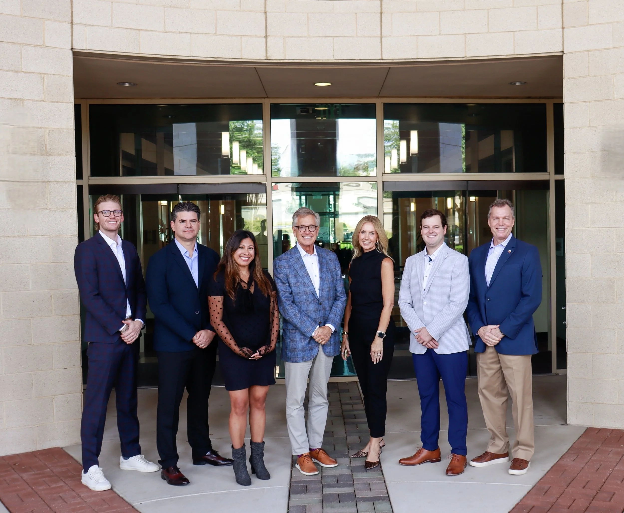 Tom Montgomery, center, with the Montgomery Capital Advisers team outside a building