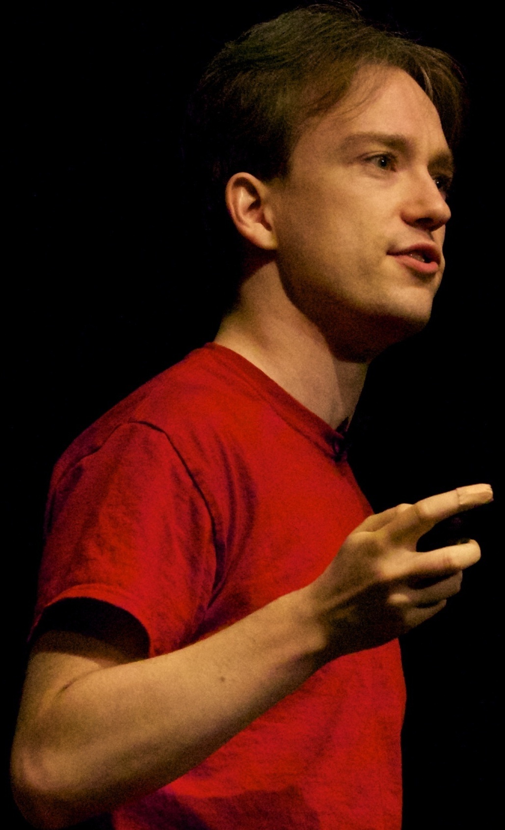 Tom Scott speaking onstage at dConstruct in 2014, wearing a red shirt