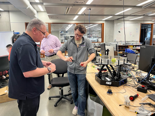 Tom Wagner looking at a robotics project with a participant at a Northwestern workbench