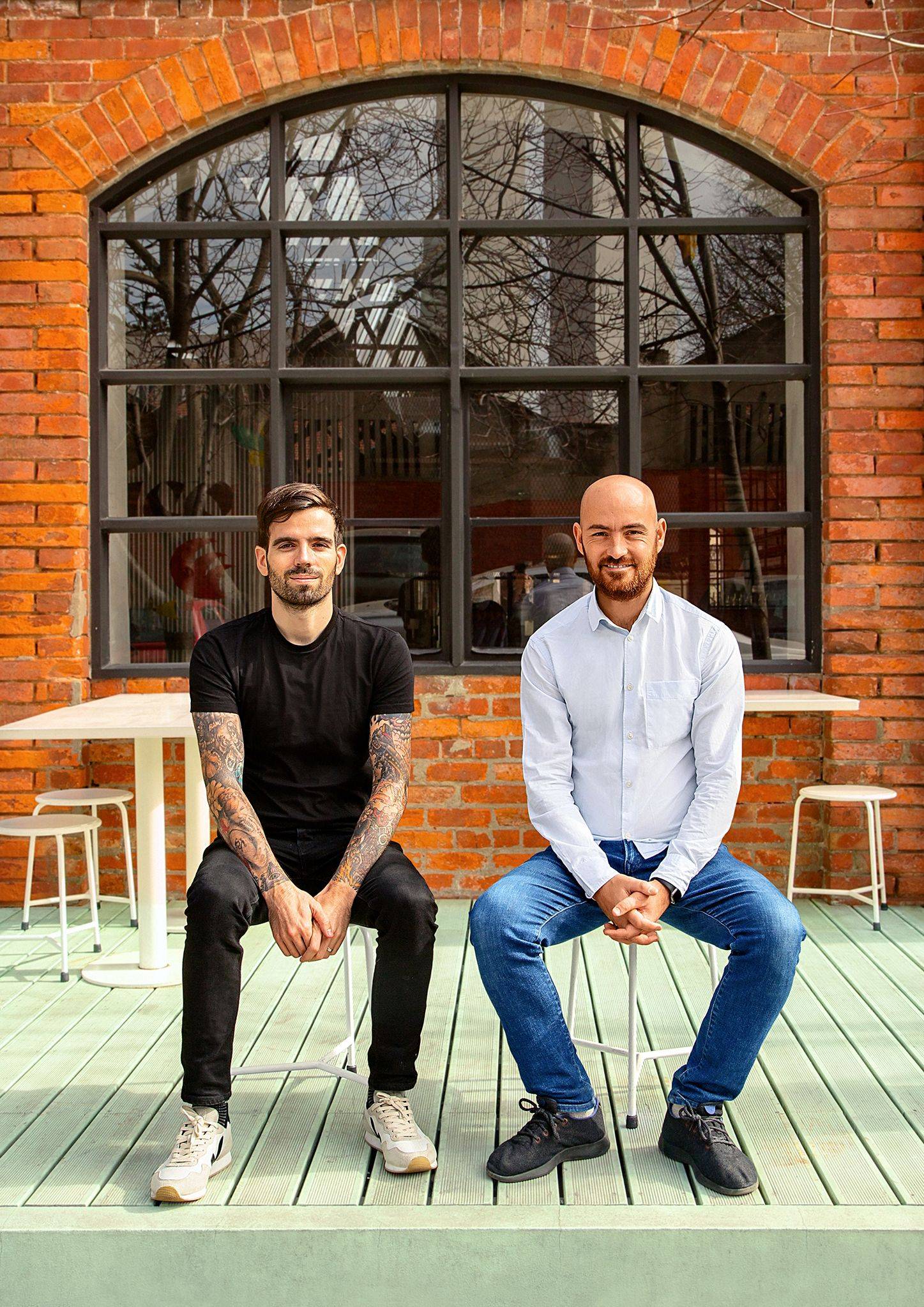 Kencko co-founders Tomás Froes and Ricardo Vice Santos seated in an industrial workspace