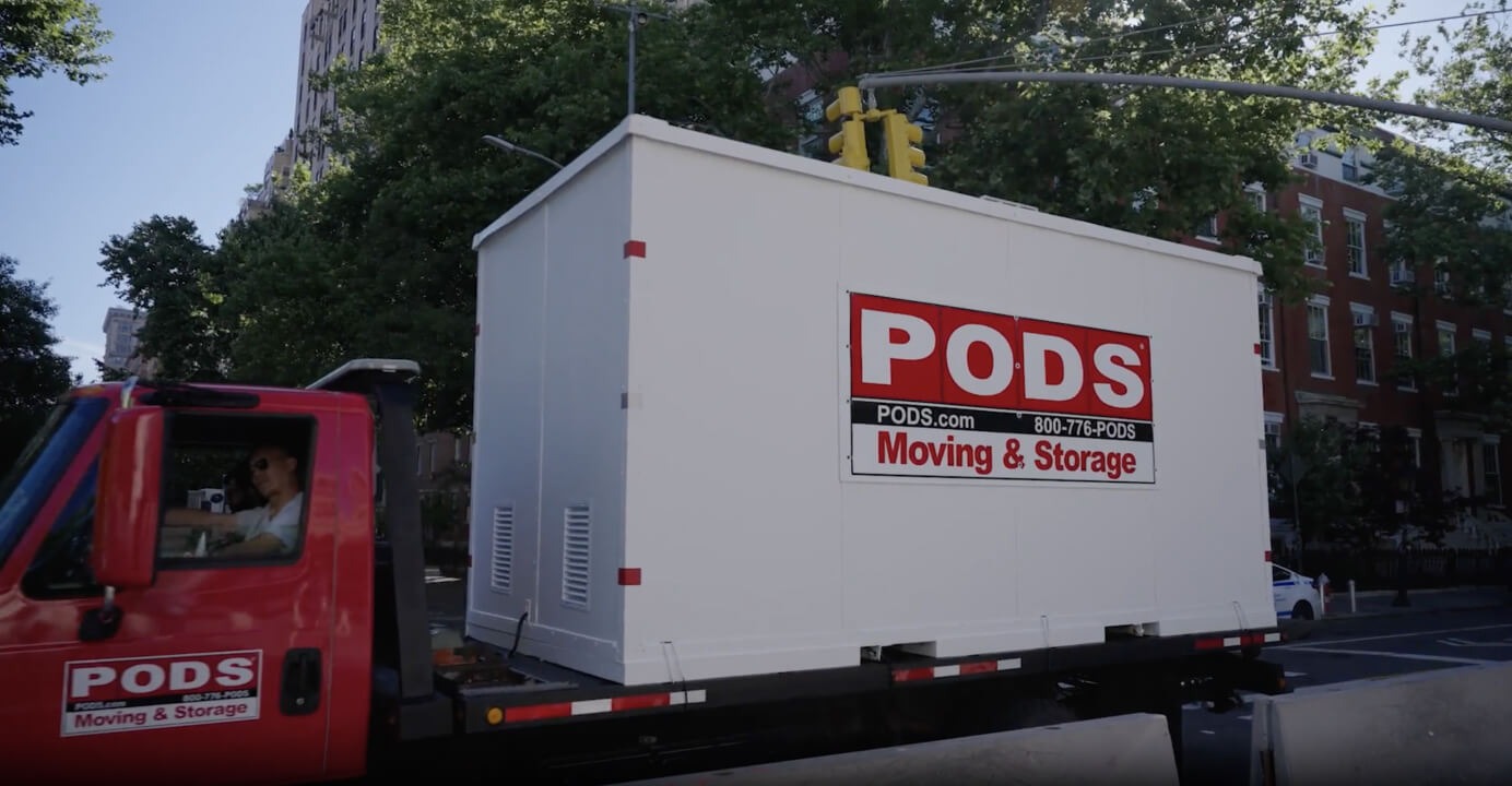A PODS container on a moving truck in a New York street