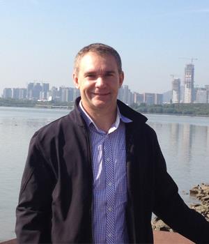 Tony Jaensch standing outdoors beside a waterfront