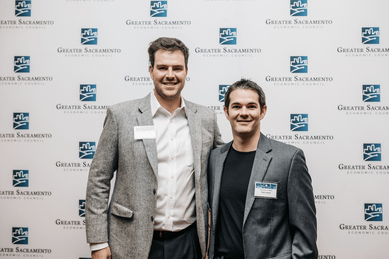 Aumni co-founders Kelsey Chase, left, and Tony Lewis, right, standing together at an event