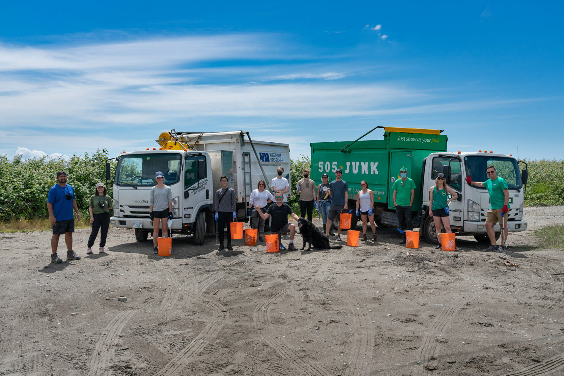 A PPCR shoreline cleanup team standing between two trucks with orange collection buckets