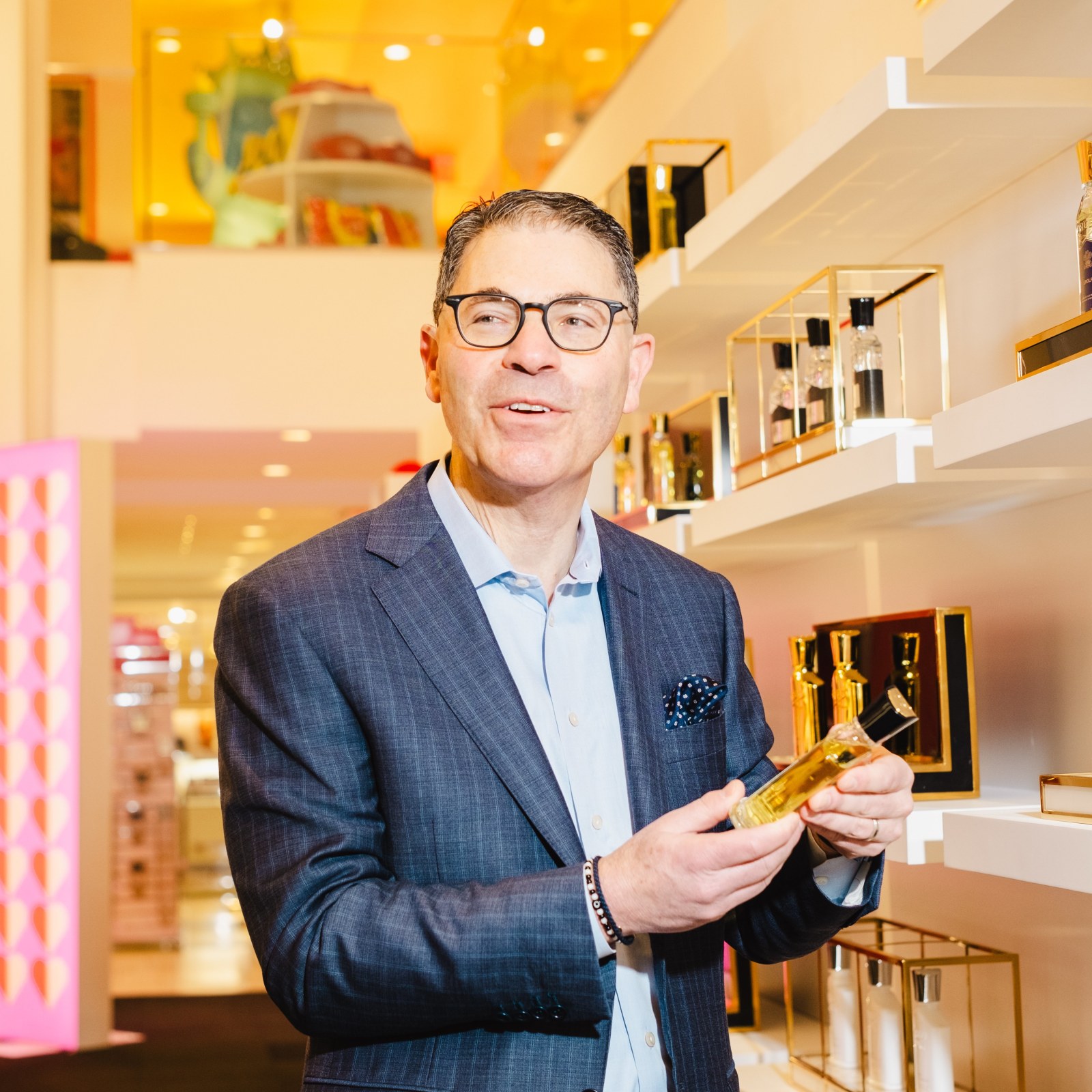 Tony Spring holding a fragrance bottle inside a department store