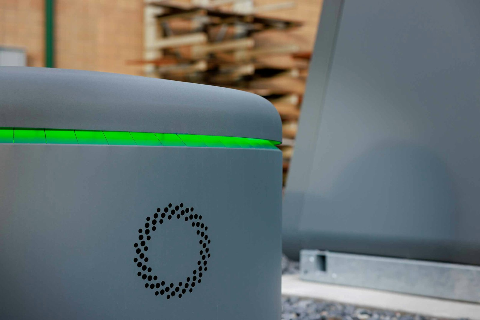 Close view of a gray Torus Spin enclosure with a green illuminated rim