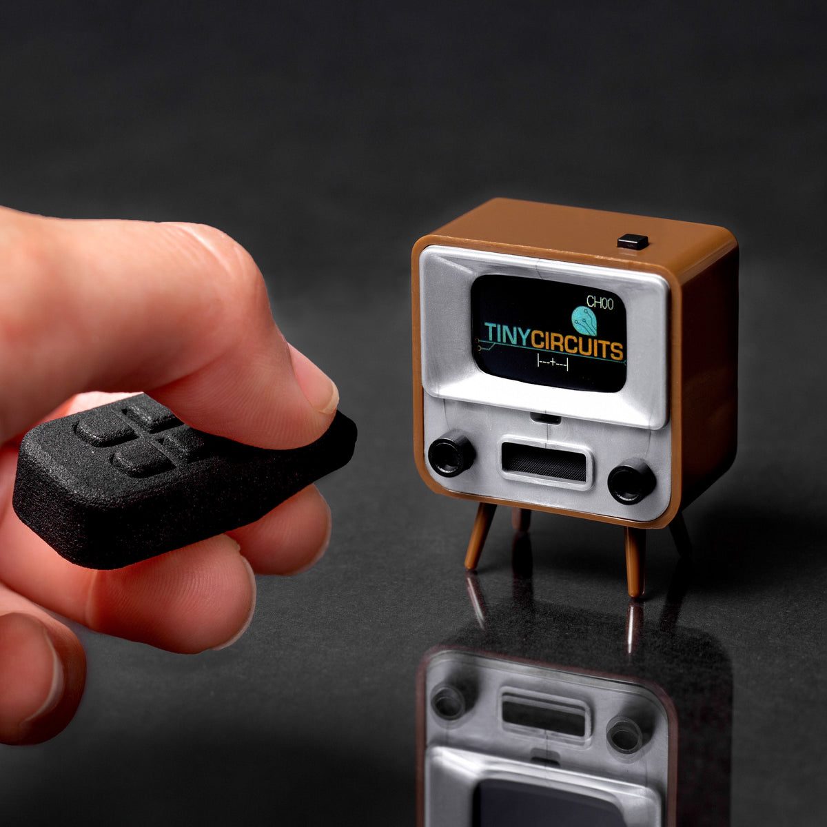 TinyCircuits TinyTV 2 miniature brown television with its tiny remote