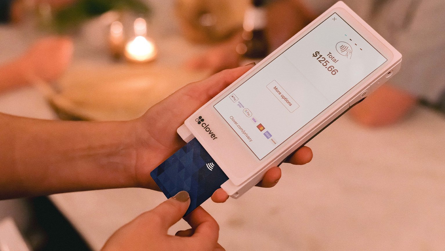 A customer inserts a payment card into a handheld Clover terminal