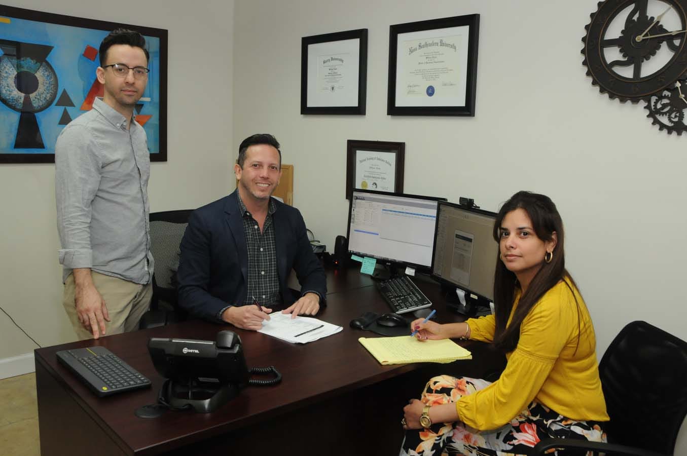 Three members of the company-labeled Trip2 product team in an office