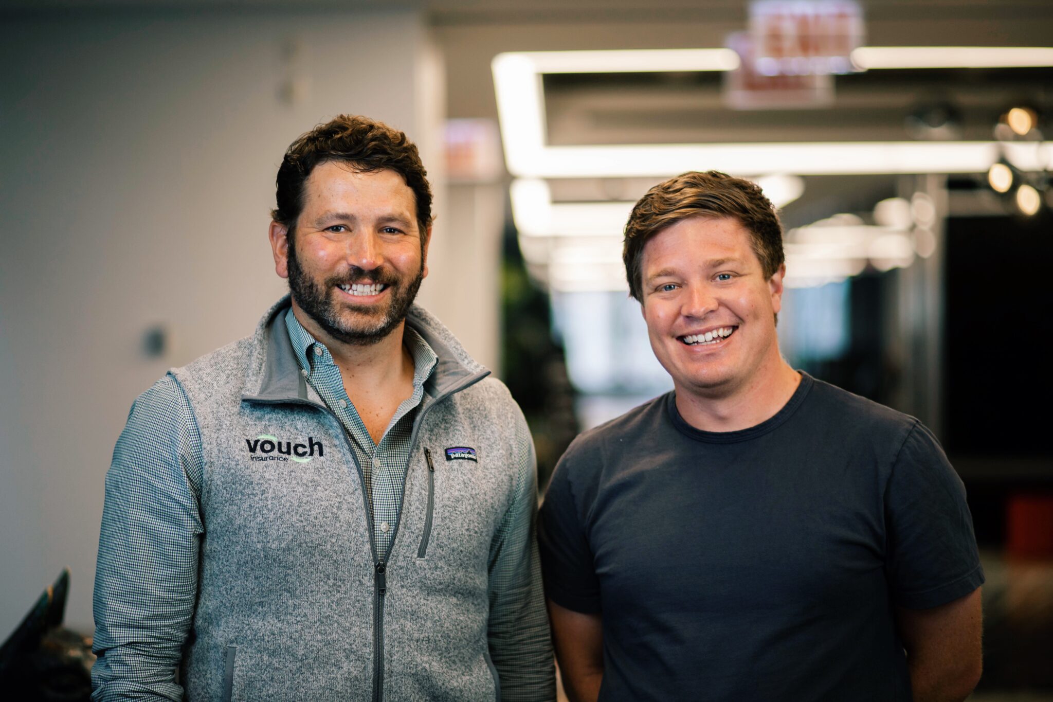 Vouch co-founders Sam Hodges and Travis Hedge smiling together in an office