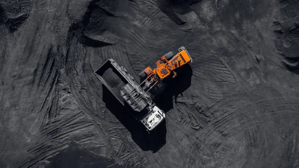 A wheel loader transferring material into a dump truck at a quarry