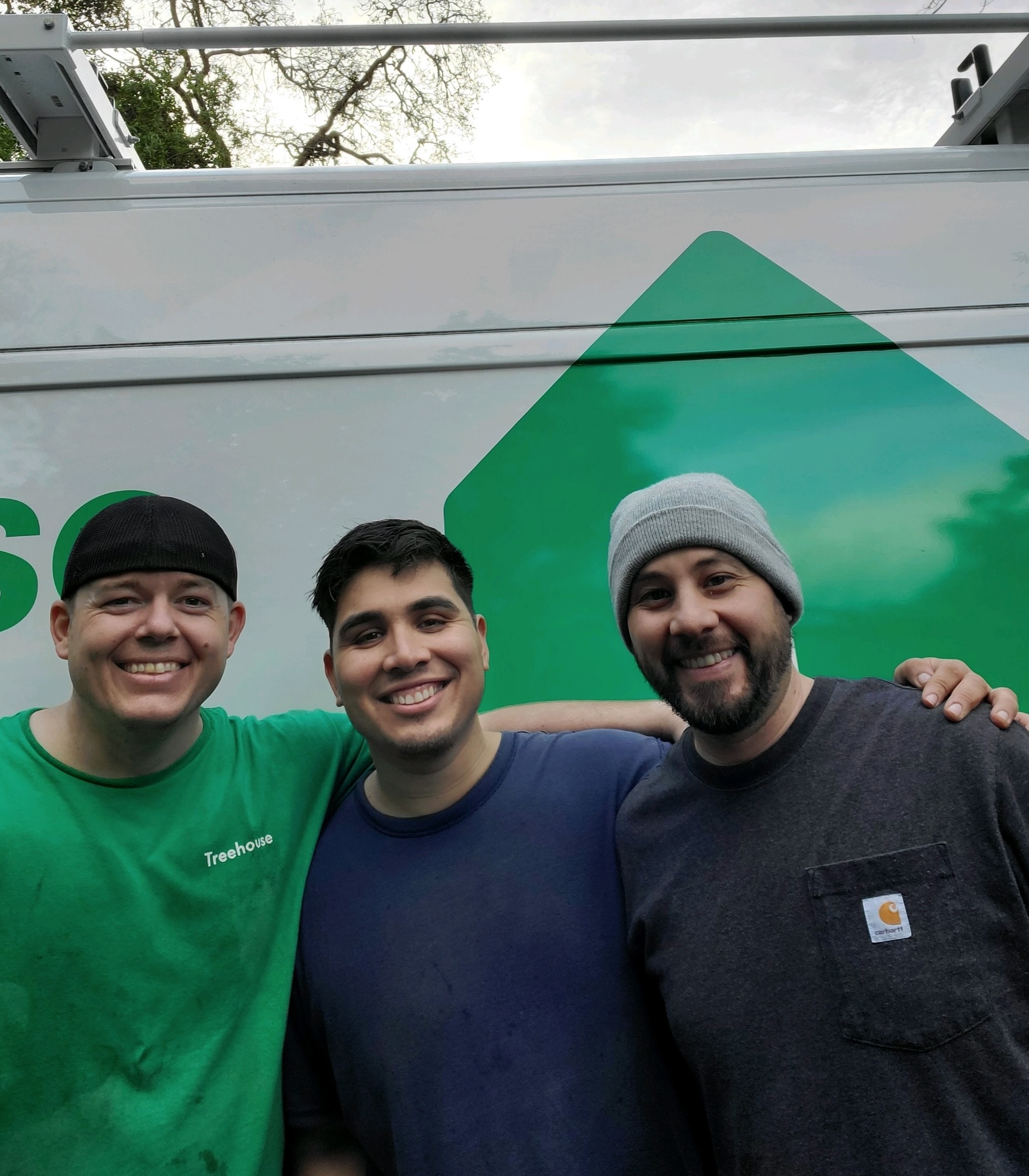 Three Treehouse electrical team members standing beside a Treehouse service van